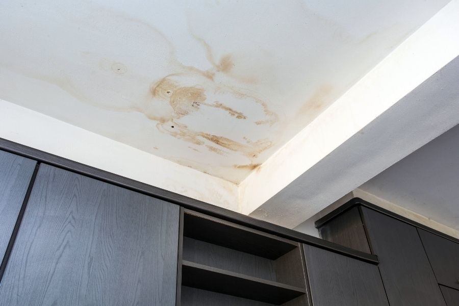 Water stains on a ceiling indicating hidden moisture damage from a burst pipe above
