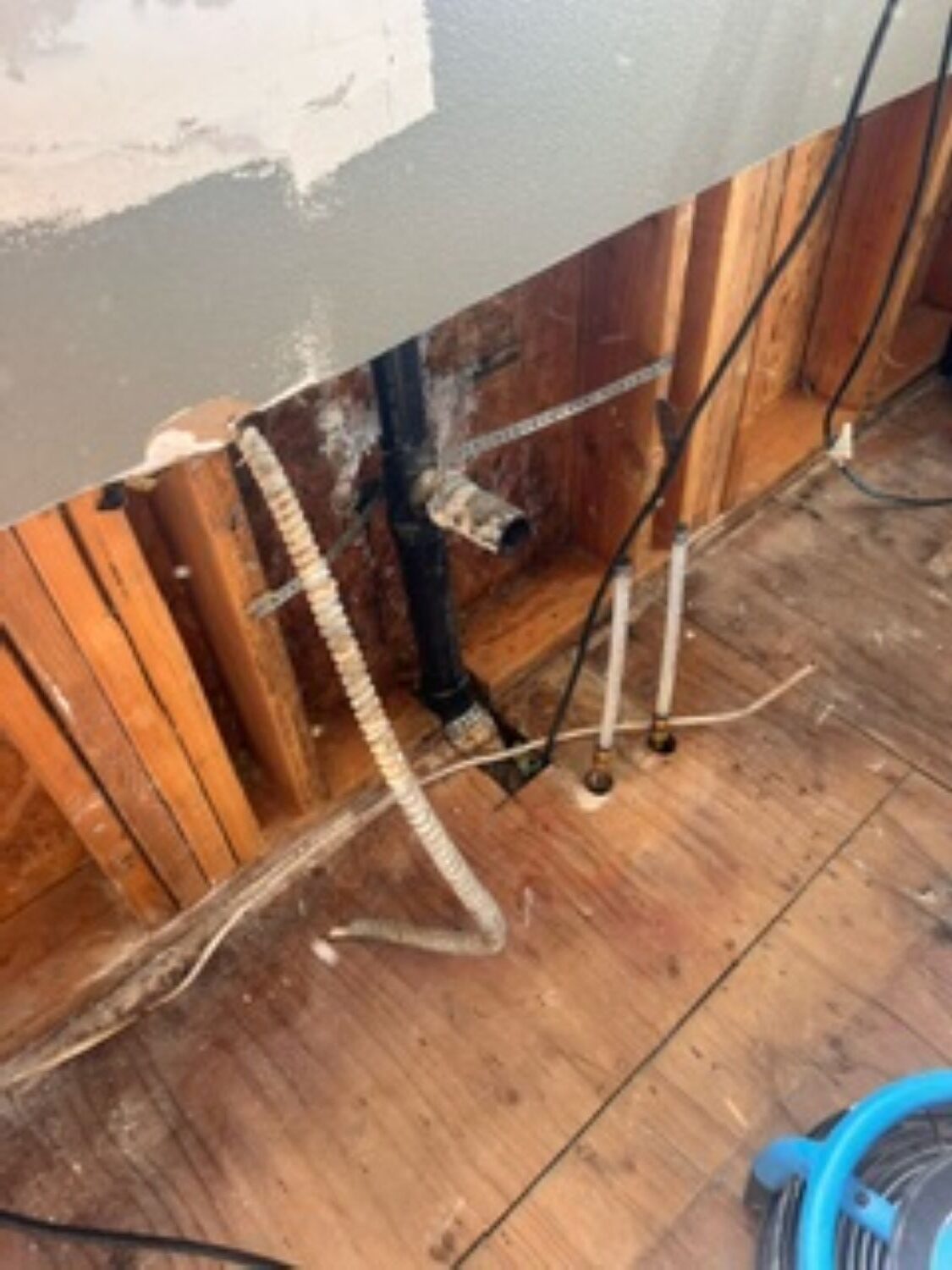 Kitchen demolition during water damage restoration removing wet drywall and cabinets