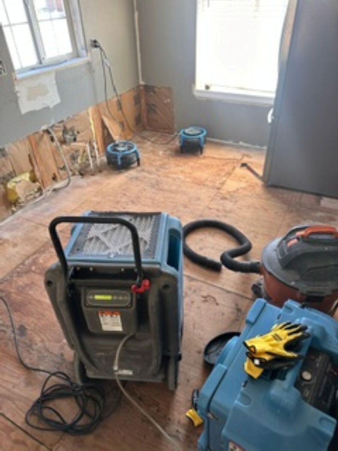 Kitchen water damage restoration progress showing cleaned and treated subfloor