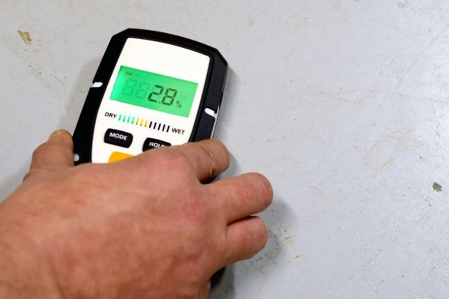 Technician using moisture meters to assess water damage in a Central Oregon home
