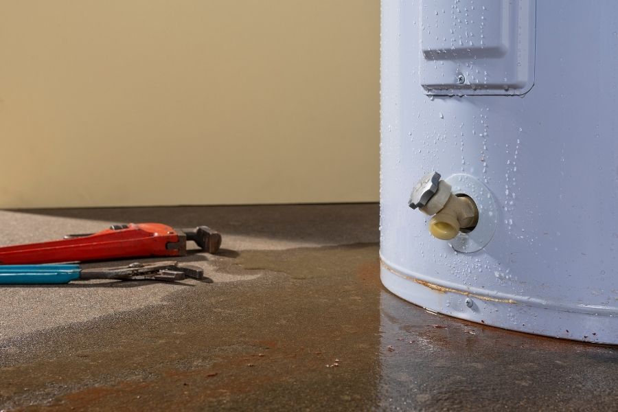 Water heater leak causing water damage to surrounding flooring and walls