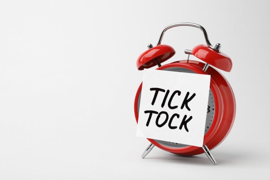 A clock with a note reading tick tock, symbolizing the urgency to act quickly after home damage