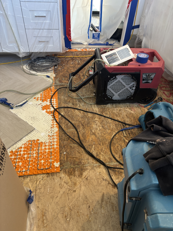 Subfloor drying in progress following bathtub drain water damage cleanup
