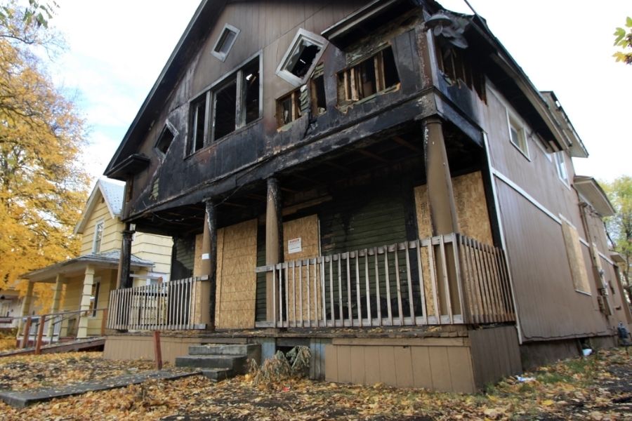 Home with windows and doors boarded up after fire damage
