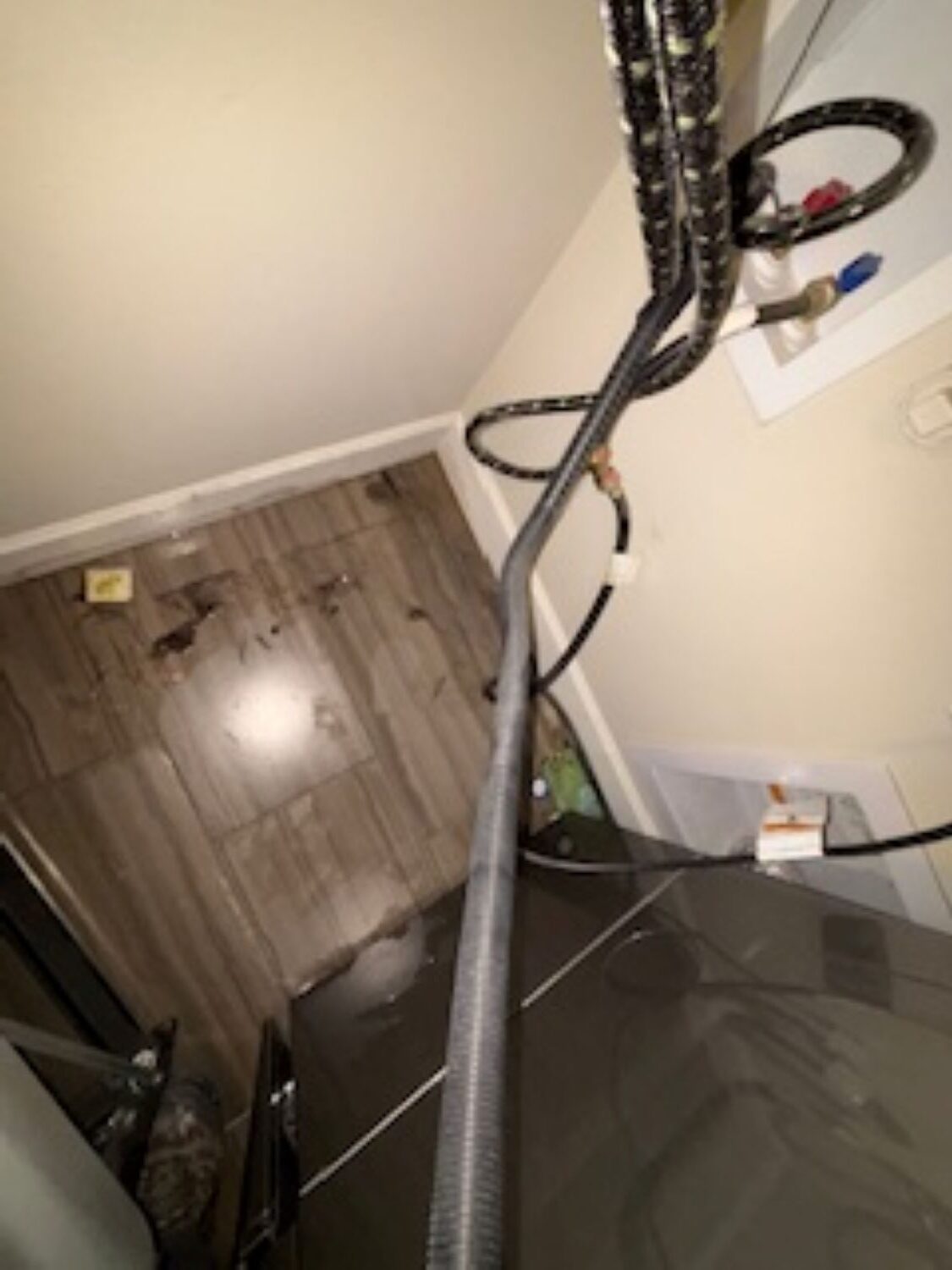 Water pooling near dryer area from failed steam fitting in Madras home laundry room