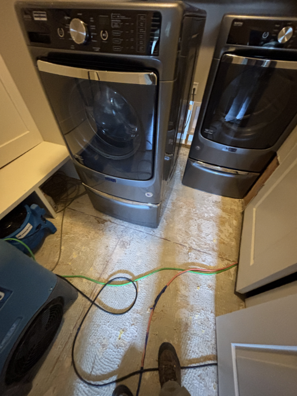 Laundry room showing water damage from dryer steam fitting failure
