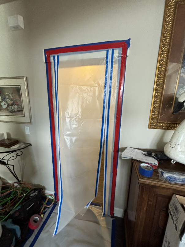 Plastic containment barrier with peel-and-seal zipper installed in water-damaged Madras home