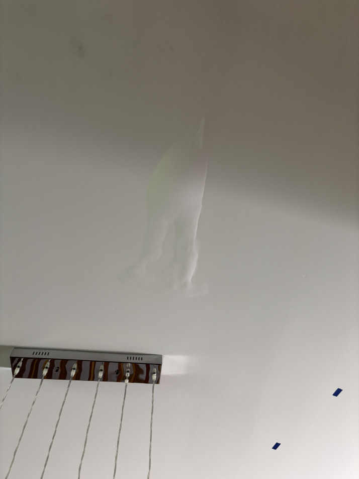 Water staining and damage visible on kitchen ceiling in a Bend condo after upper-level bathroom leak