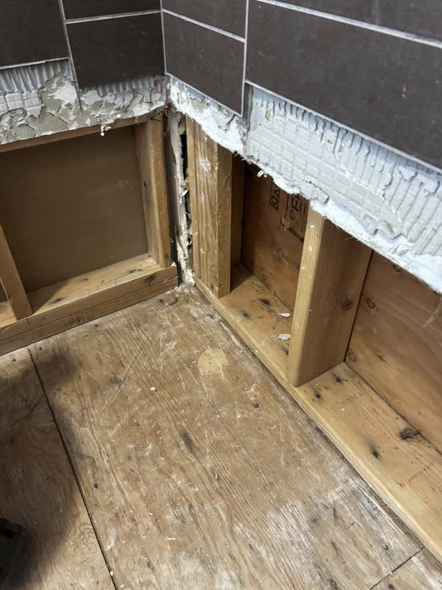 Drywall removed from kitchen ceiling exposing joists after water traveled between levels