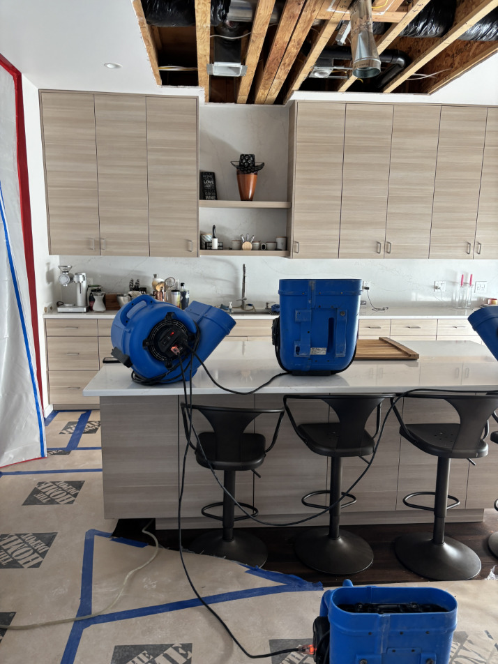 Dehumidifier and air movers running in condo unit during structural drying