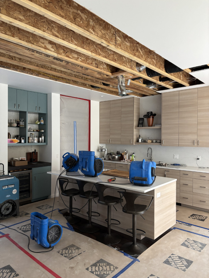 Multiple air movers positioned in open kitchen area for drying after water damage
