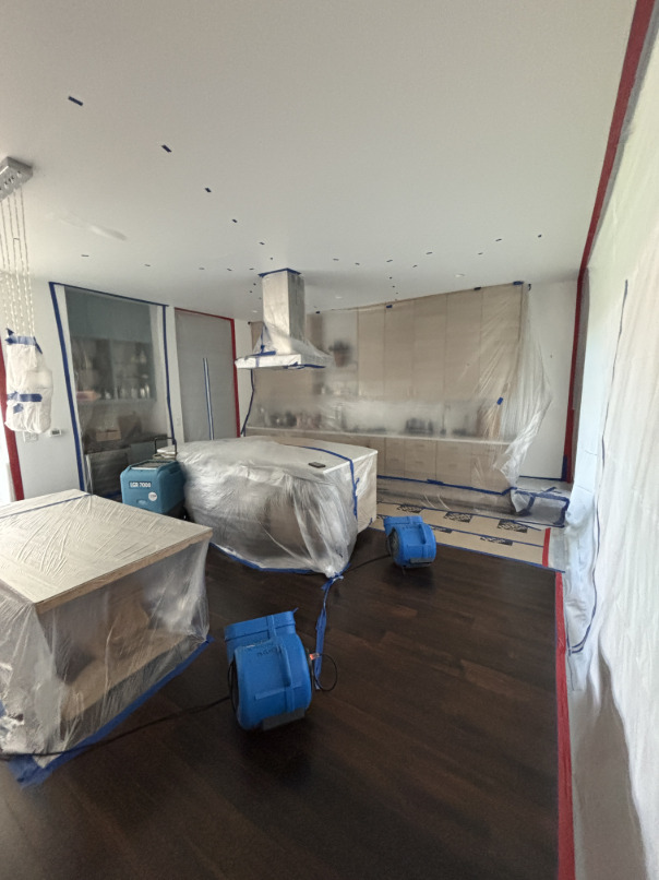 Air movers and dehumidifiers running in main level living area during drying phase