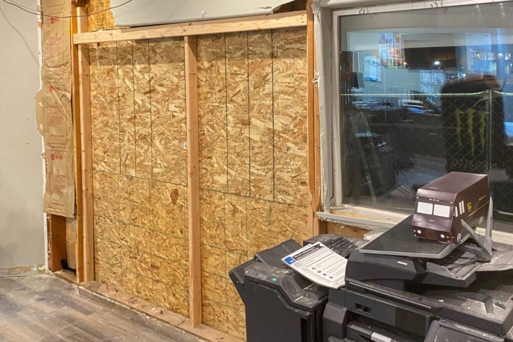 Commercial board up of a damaged storefront wall in Bend, OR